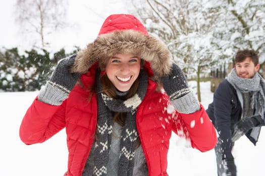 Young couple having snowball fight