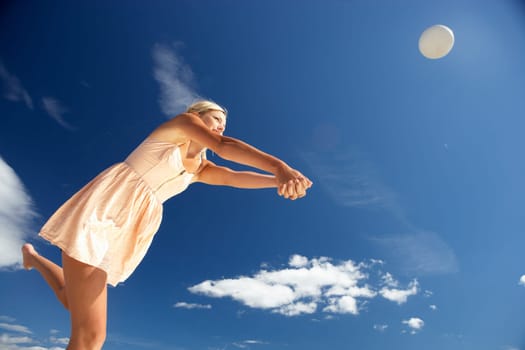 Teenage girl playing beach volleyball