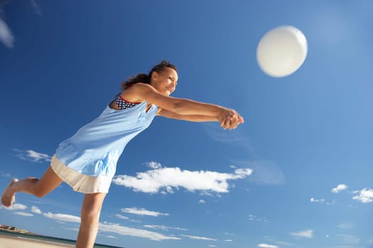 Teenage girl playing beach volleyball