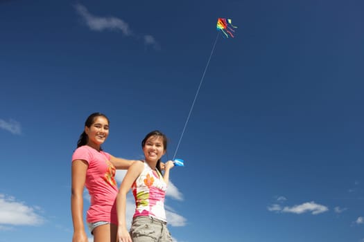 Teenage girls flying a kite