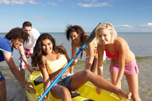 Teenagers in sea with canoe