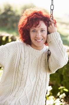 Woman on country garden swing