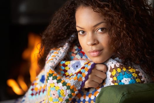 Young woman sitting by open fire