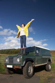 Young woman in countryside with SUV