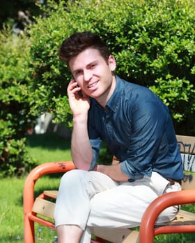 Relaxed handsome russian man in park calling