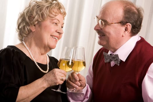Portrait of senior couple celebrating their golden wedding with champagne