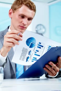 Portrait of a serious manager holding document