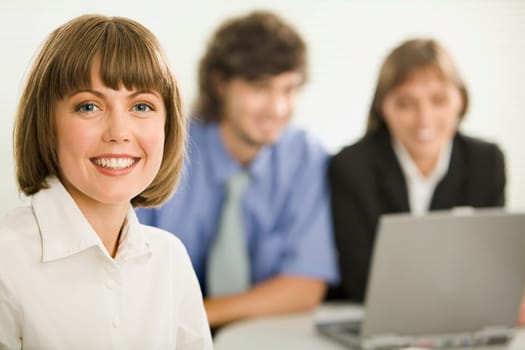 Successful young business woman with charming confident smile on the background businesspeople