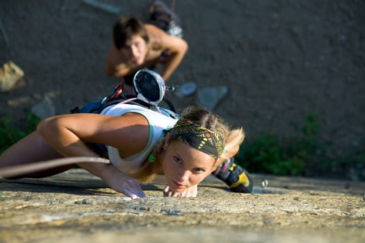 Photo of woman in sport wear climbing up mountain