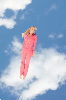 Creative image of sporty girl keeping straight on background of cloudy sky