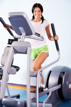 Portrait of brunette doing exercises on the simulator