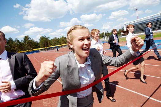Photo of happy businesswoman crossing finish line during race