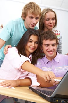 Portrait of clever students sitting at lesson and looking at laptop monitor