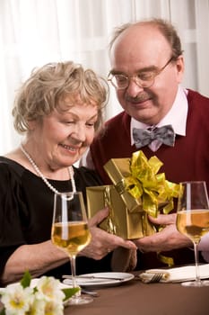 Image of happy seniors sitting at table during family celebration