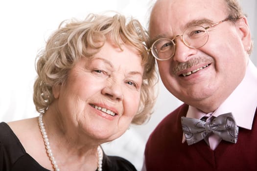 Portrait of aged woman and man looking at camera with smiles