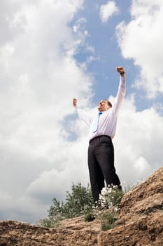 Photo of relaxed businessman standing and raising his arms outdoors in summer