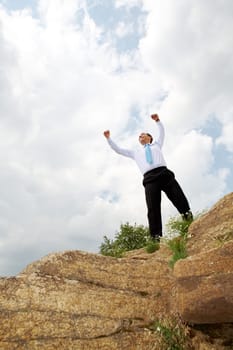 Photo of relaxed businessman standing and raising his arms outdoors in summer