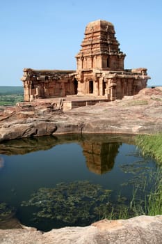 Upper Shivalaya on top of northern hill and its reflection in water, Badami, Karnataka, India, Asia