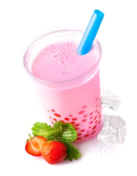 Blended glass of frothy strawberry bubble tea with red tapioca pearls and ripe strawberries served with a drinking straw