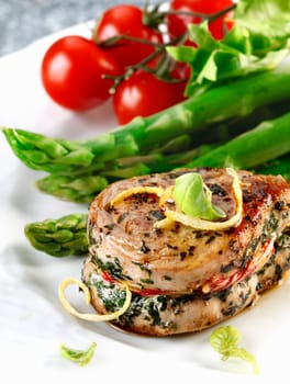 Sirloin steak of a pork and asparagus and some tomatoes. Fresh red meat meal menu