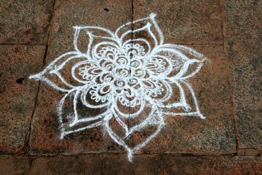 Skillful Rangoli artwork using white stone powder