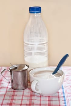 Plastic bottle and cup with capuchin on the table.