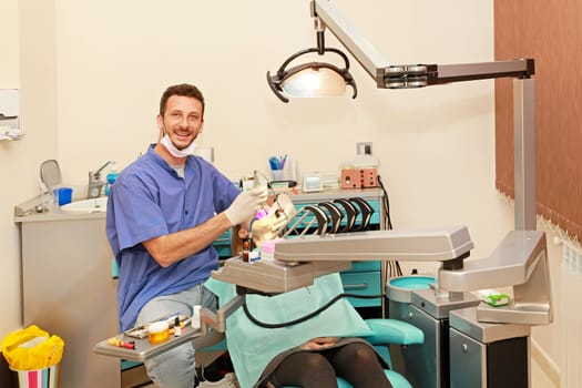Smiley doctor and girl in dentist office