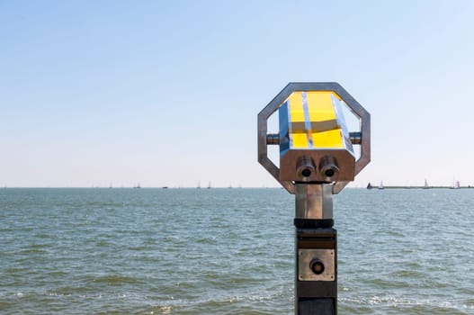 Pay binoculars with sea full of sails in the background.