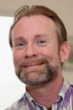 Good looking caucasian male smiling at the viewer close up.