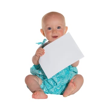 Cute young baby with a lovely wide eyed expression holding a blank sheet of paper and learning from the texture, touch and feel of the page.