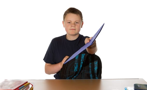 Teenager handing in his completed assignment for marking as he leans across the table holding out a blue folder