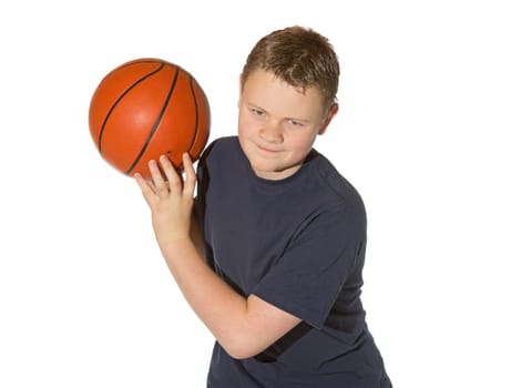 Teenager looking down watching and waiting for an opportunity to throw or bounce the basketball which he is holding above his shoulder