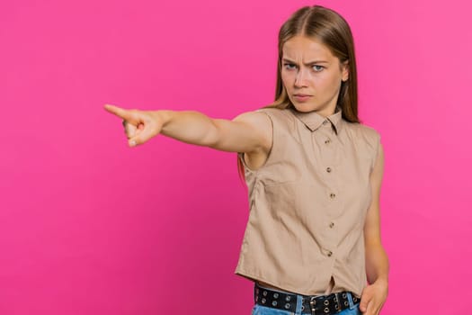 Get out of here. You are fired. Young Caucasian woman pointing finger away asking to leave her alone, strict boss firing, conflict, quarrel. Blonde girl isolated on pink studio background indoors