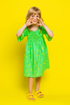Keep my secrets, silence. Young school girl whisper news rumors holding hands near mouth share gossip quiet. Preteen child kid telling interesting confidential story on yellow background. Vertical