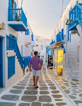 Mykonos Greece April 2018, Tourists at the streets of the Greek village in Greece, colorful streets of Mikonos village shopping street in the evening