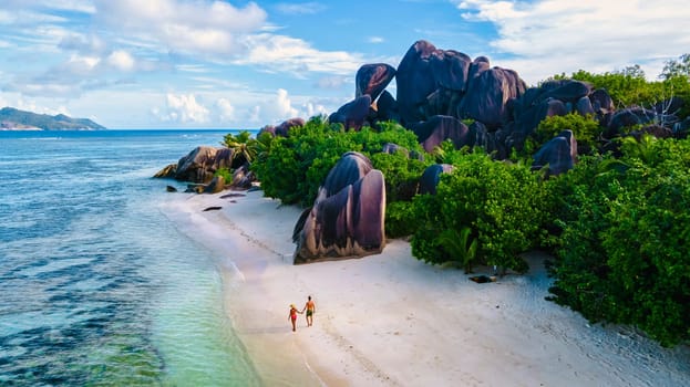 Anse Source d'Argent beach, La Digue Island, Seychelles, a couple of men and woman at the beach during sunset, luxury vacation in the Seychelles at a white tropical beach with turqouse colored ocean