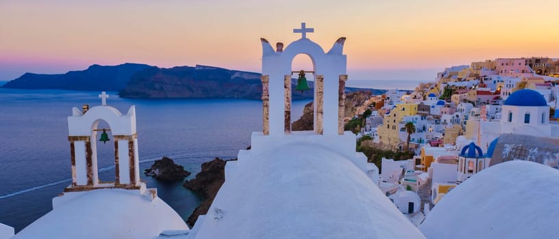 White churches and blue domes by the ocean of Oia Santorini Greece, a traditional Greek village in Santorini at sunset. Oia Santorini at sunset