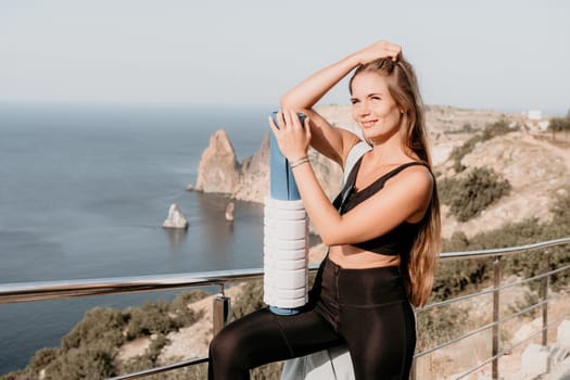 Fitness woman sea. Outdoor workout on yoga mat in park near to ocean beach. Female fitness pilates yoga routine concept. Healthy lifestyle. Happy fit woman exercising with rubber band in park.