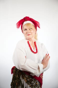 Portrait of cheerful funny adult mature woman solokha. Female model in clothes of national ethnic Slavic style. A stylized Ukrainian, Belarusian or Russian woman poses in a comic photo shoot