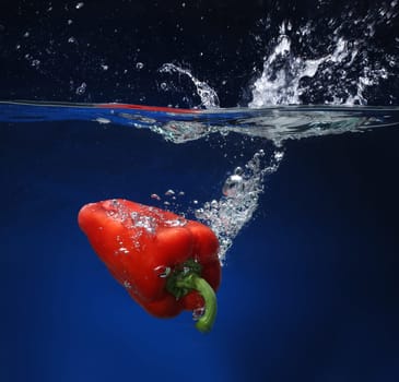 Red pepper falling into water
