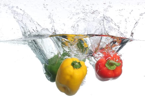 Three peppers falling into water