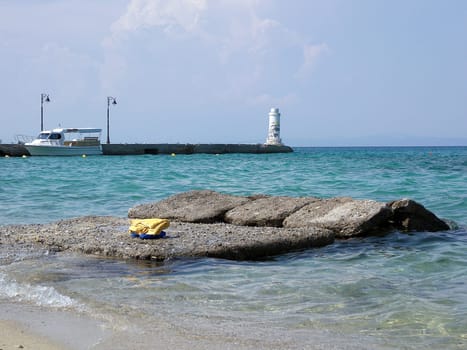 Beach, rocks ship and a lighthouse in Chalkidiki of Greece