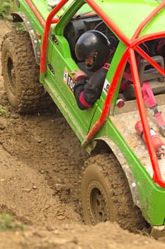 MOHELNICE, CZECH REPUBLIC - JUNE 10. Unidentified racer at green  off-road car leaves muddy puddle in the "SHOCK CUP Trial 2012"" on June 10, 2012 in the town of Mohelnice, Czech Republic."
