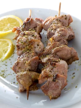 Greek Souvlaki or Kalamaki with lemons, close-up, isolated on white background