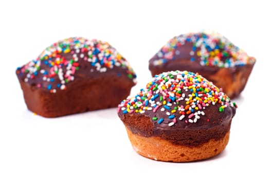 Three chocolate cakes with multicoloured truffle, for party, isolated on white background