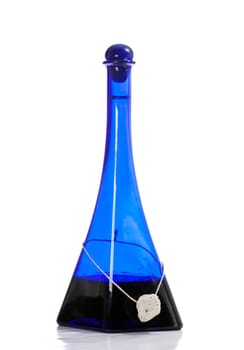 Blue bottle with alcohol drink, and a stone, use as home decoration, on white background