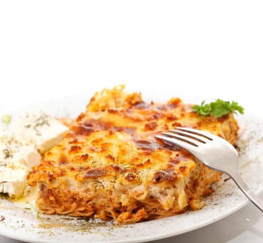 Pastitsio & feta cheese in a plate, greek traditional food, on white background