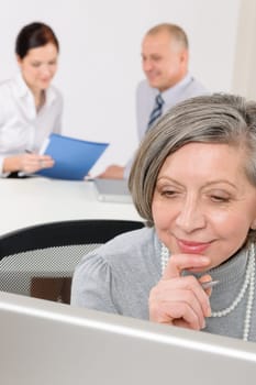 Executive senior businesswoman work on computer with colleagues in office