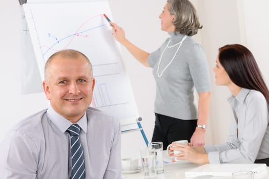 Smiling businessman during team meeting with colleagues give presentation