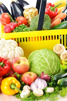 Composition with plastic shopping basket and grocery isolated on white